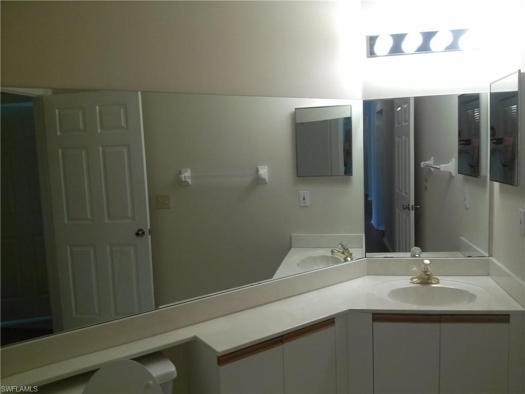 110 Bennington Drive, Unit 8 Naples, FL 34104 - Photo 14 of 18 a bathroom with a sink and mirror
