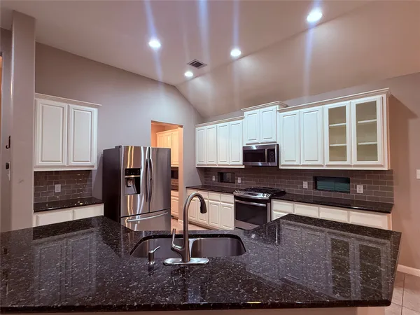 a kitchen with sink refrigerator and cabinets