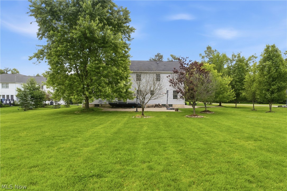 11678 Dunham Road Northfield, OH 44067 - Photo 33 of 38 Expansive green lawn with mature trees and a two-story white exterior
