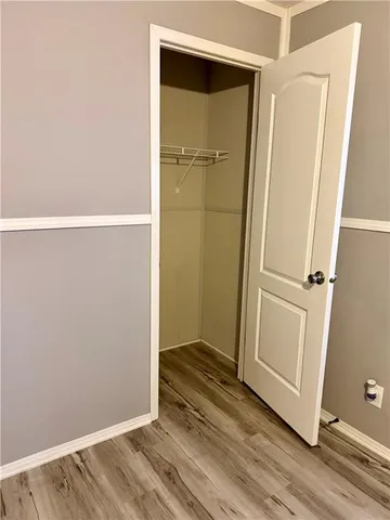 a view of a room with wooden floor and a ceiling fan
