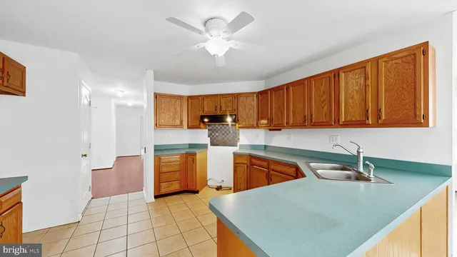 a kitchen with stainless steel appliances granite countertop a sink a stove cabinets and entryway