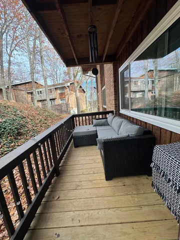 a view of balcony with wooden floor and outdoor seating