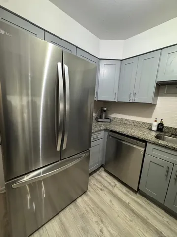 a kitchen with granite countertop a refrigerator and a sink