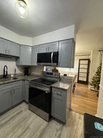 a kitchen with stainless steel appliances kitchen island granite countertop a stove and a sink