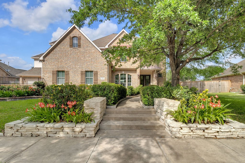 7306 Starflower Katy, TX 77494 - Photo 2 of 50 a front view of a house with a yard and a garden