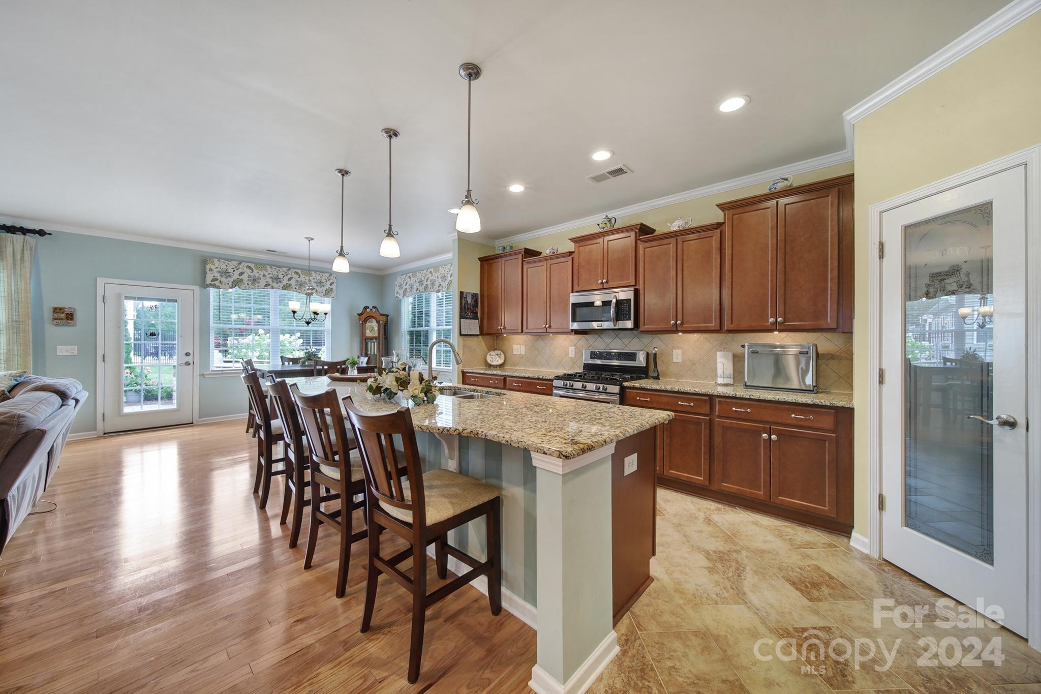 4362 Perth Road Fort Mill, SC 29707 - Photo 5 of 34 a kitchen with stainless steel appliances granite countertop a kitchen island a stove a refrigerator a sink a dining table and chairs