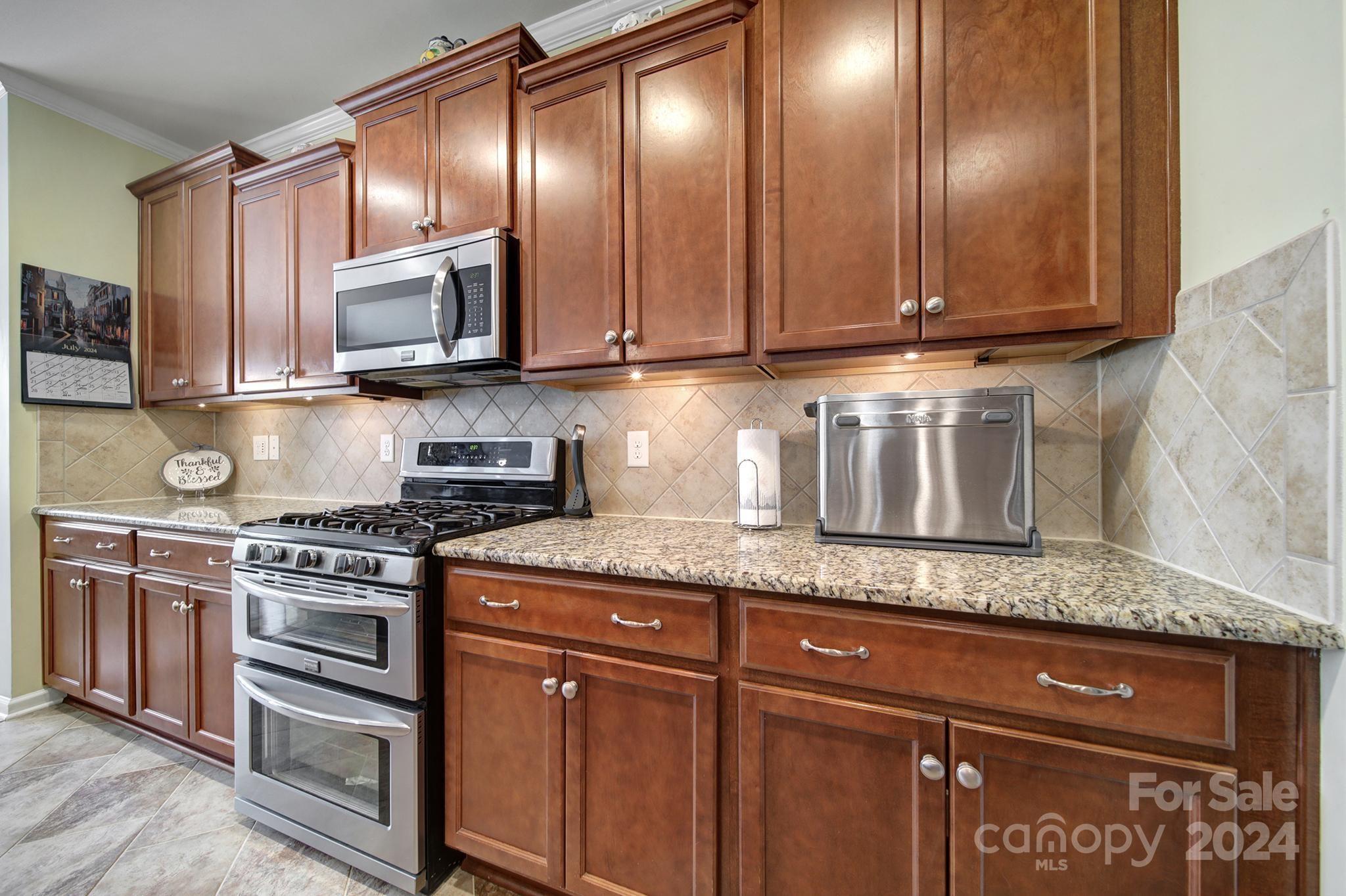 4362 Perth Road Fort Mill, SC 29707 - Photo 8 of 34 a kitchen with granite countertop stainless steel appliances a stove a sink and cabinets