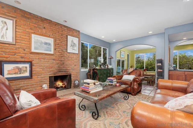 a living room with furniture fireplace and a large window