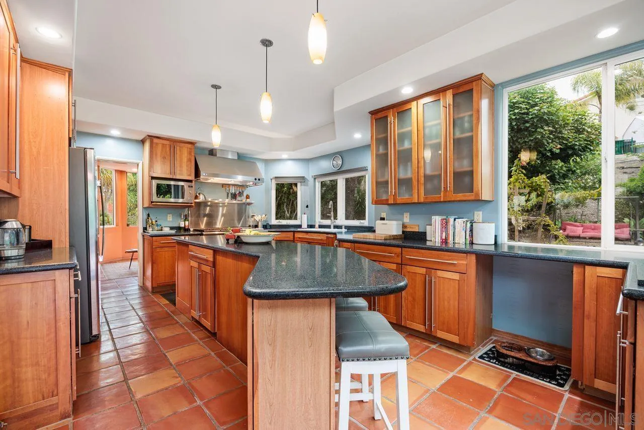 2238 Oceanview Road Oceanside, CA 92056 - Photo 13 of 50 a kitchen with stainless steel appliances granite countertop a stove a sink a refrigerator and a living room view