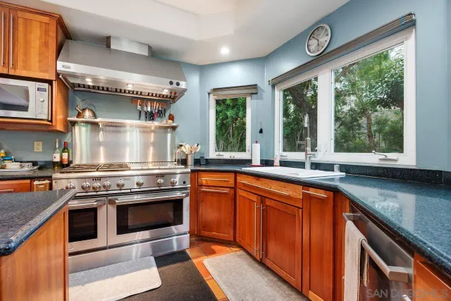 a kitchen with stainless steel appliances granite countertop a stove and a sink