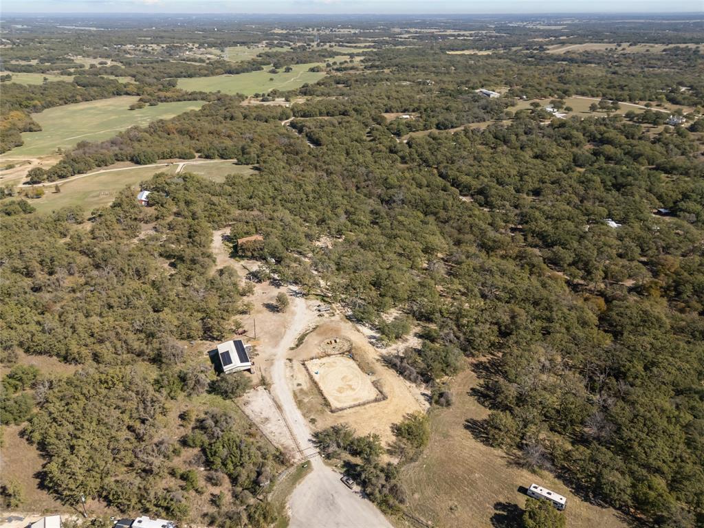 Aerial view of property and surrounding area with a forest