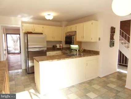 a kitchen with refrigerator and cabinets
