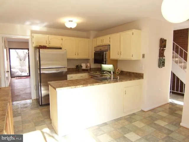 a kitchen with refrigerator and cabinets