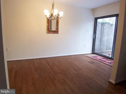 a view of a room with wooden floor and chandelier