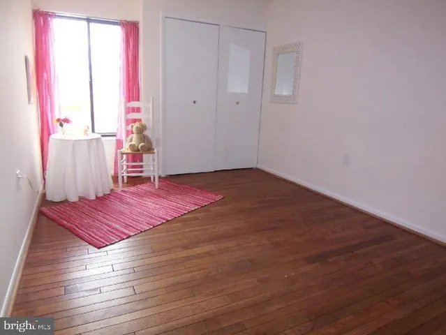 a bedroom with a bed and a lamp on dresser