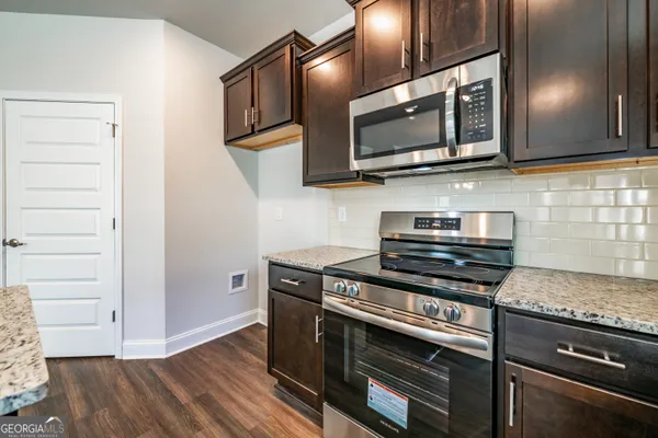 a kitchen with stainless steel appliances granite countertop a stove microwave and sink