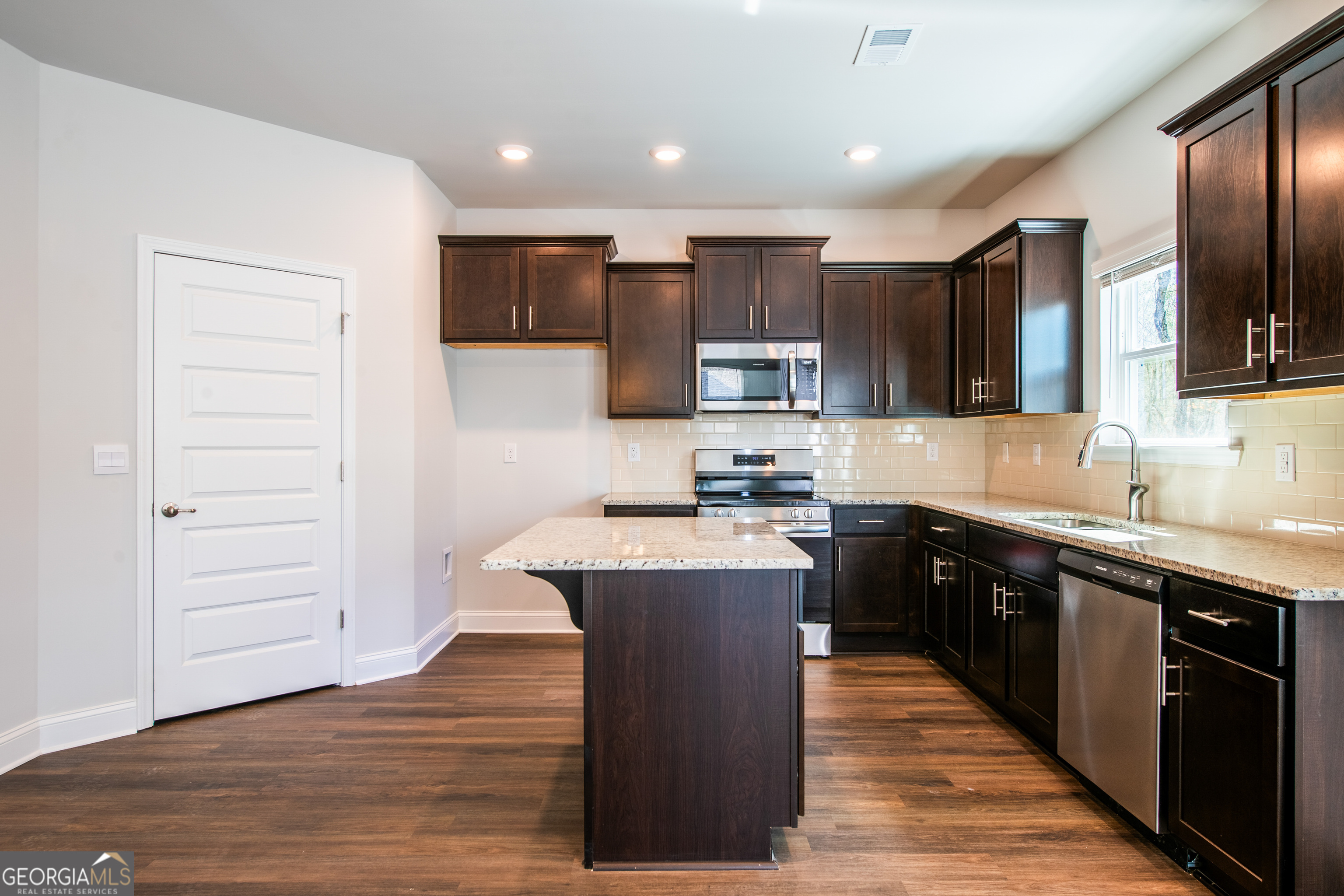 229 Carsons Walk Macon, GA 31206 - Photo 17 of 43 a large kitchen with stainless steel appliances wooden floors and wooden cabinets
