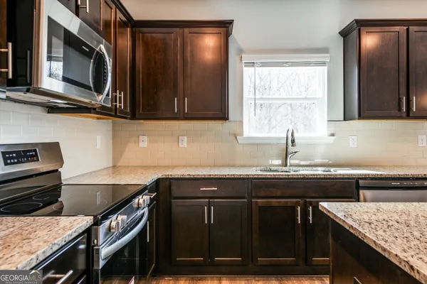 a kitchen with granite countertop a stove and a sink