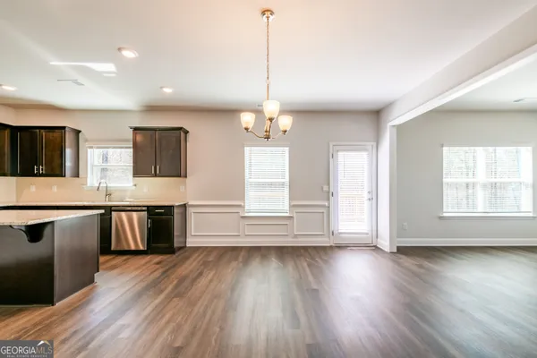 a kitchen with kitchen island granite countertop a stove top oven a sink with wooden floors