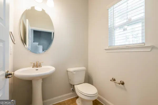 a bathroom with a sink toilet and a mirror