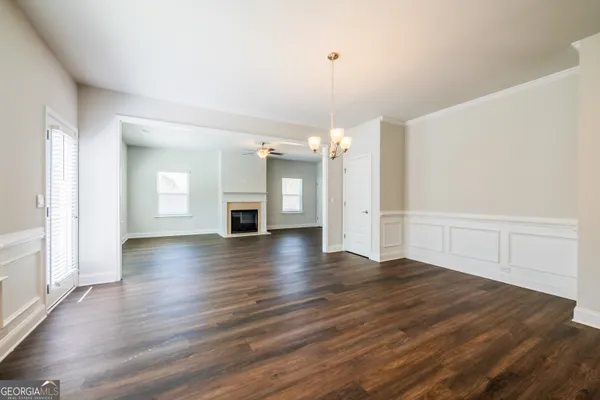 an empty room with wooden floor and fireplace