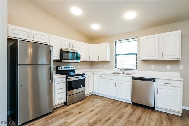 a kitchen with stainless steel appliances a refrigerator sink and microwave