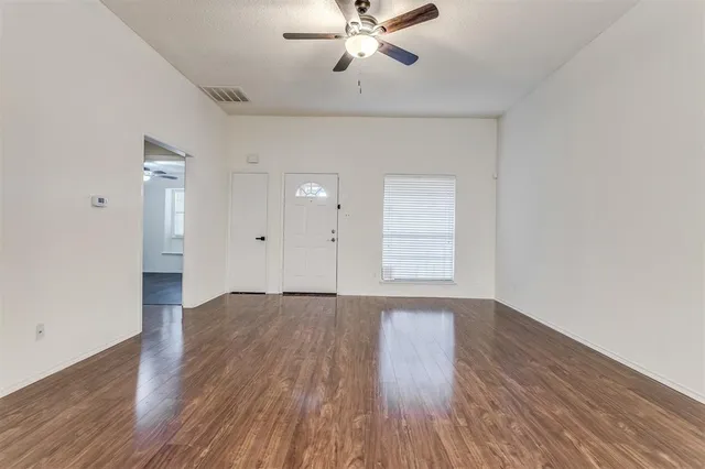 wooden floor in an empty room with a window