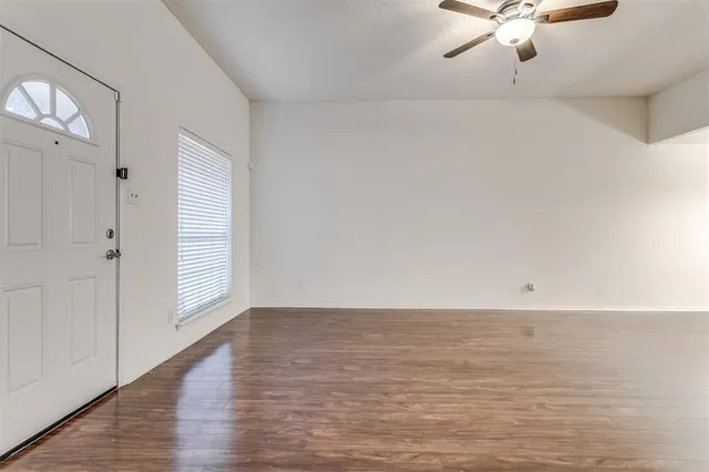 a view of an empty room with chandelier fan