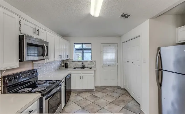 a kitchen with a refrigerator stove and sink