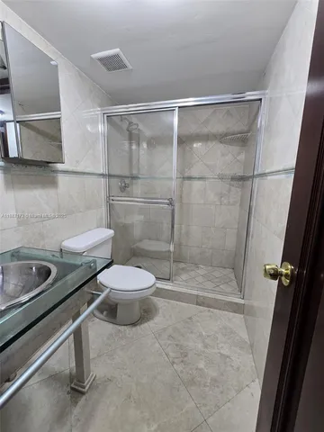 a bathroom with a sink a toilet and mirror