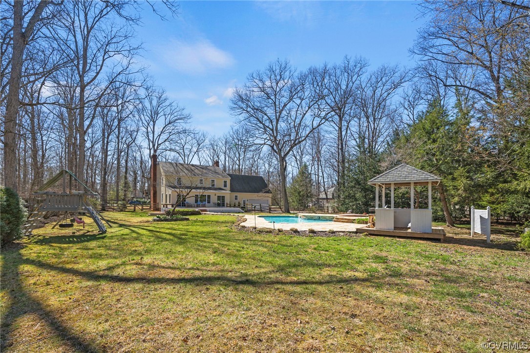 2039 Albion Road Midlothian, VA 23113 - Photo 49 of 49 a swimming pool is in front of a brick house with large trees