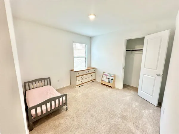 a view of a bedroom with furniture and window