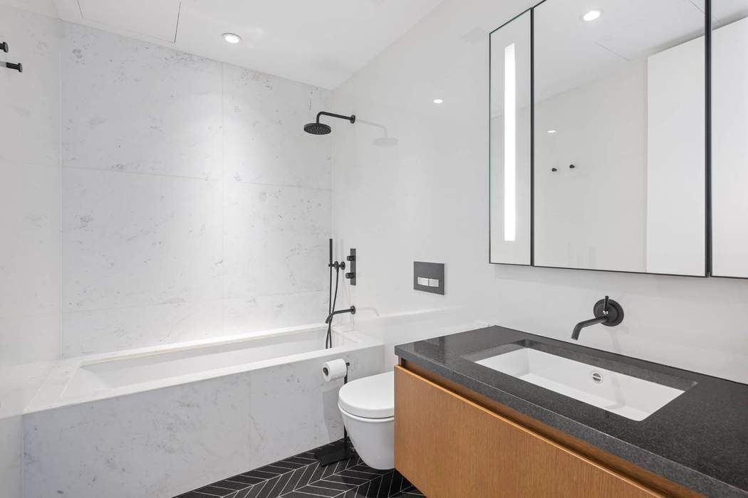 570 Broome Street, Unit 12B Manhattan, NY 10013 - Photo 9 of 17 a bathroom with a granite countertop sink a toilet and shower