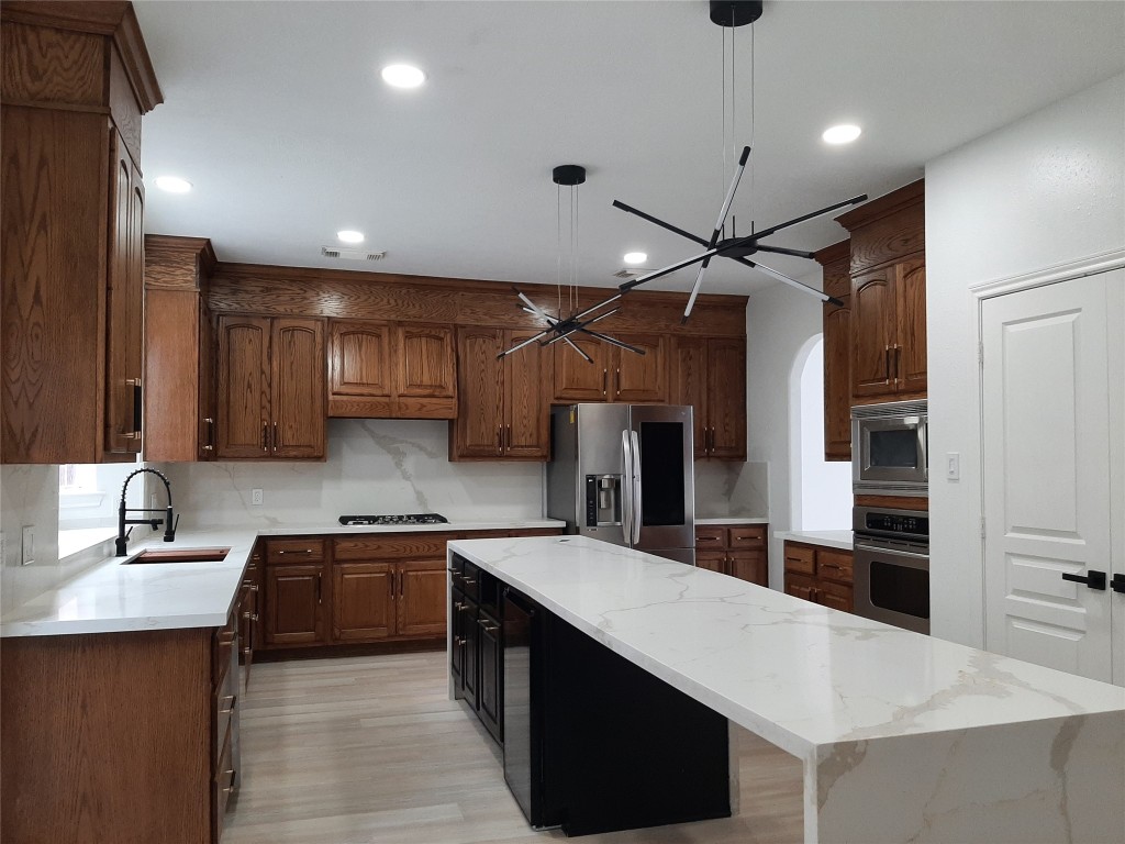 4214 Blue Sage Terrace Spring, TX 77388 - Photo 18 of 50 a kitchen with stainless steel appliances a sink and a refrigerator