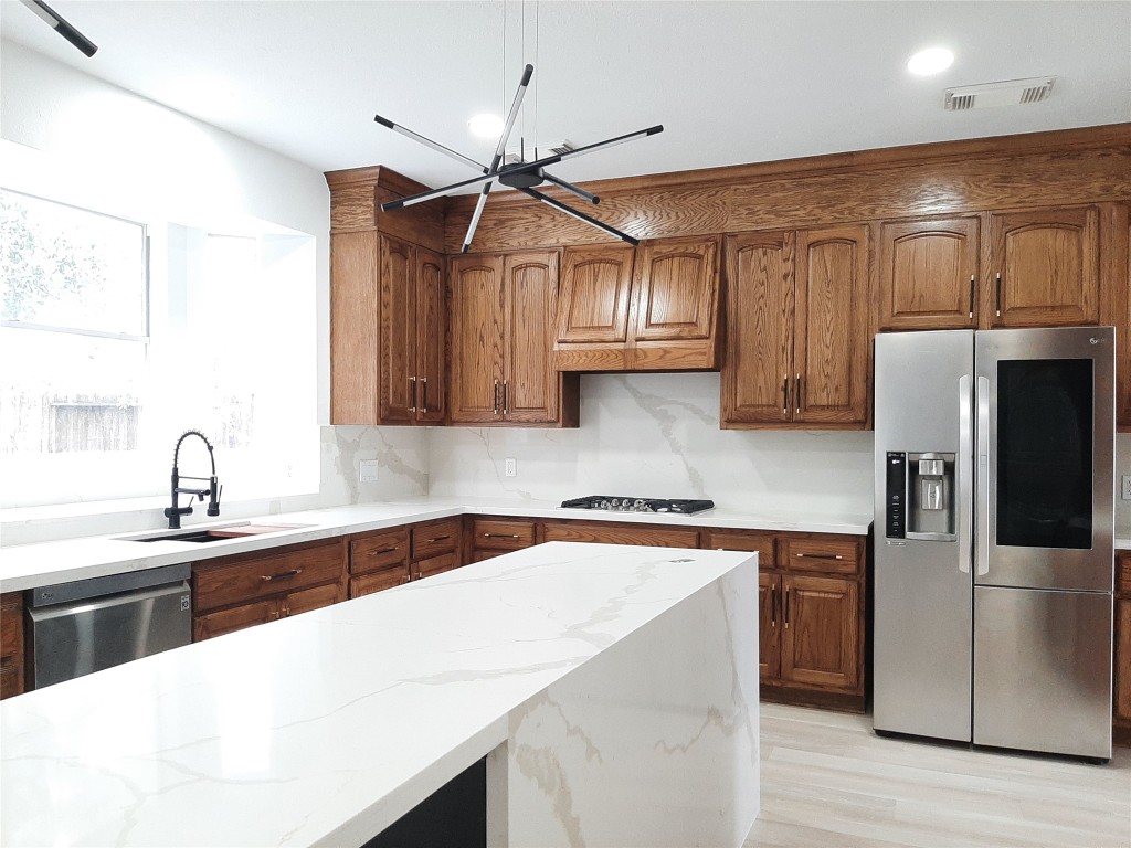 4214 Blue Sage Terrace Spring, TX 77388 - Photo 19 of 50 a kitchen with granite countertop a sink stainless steel appliances and cabinets