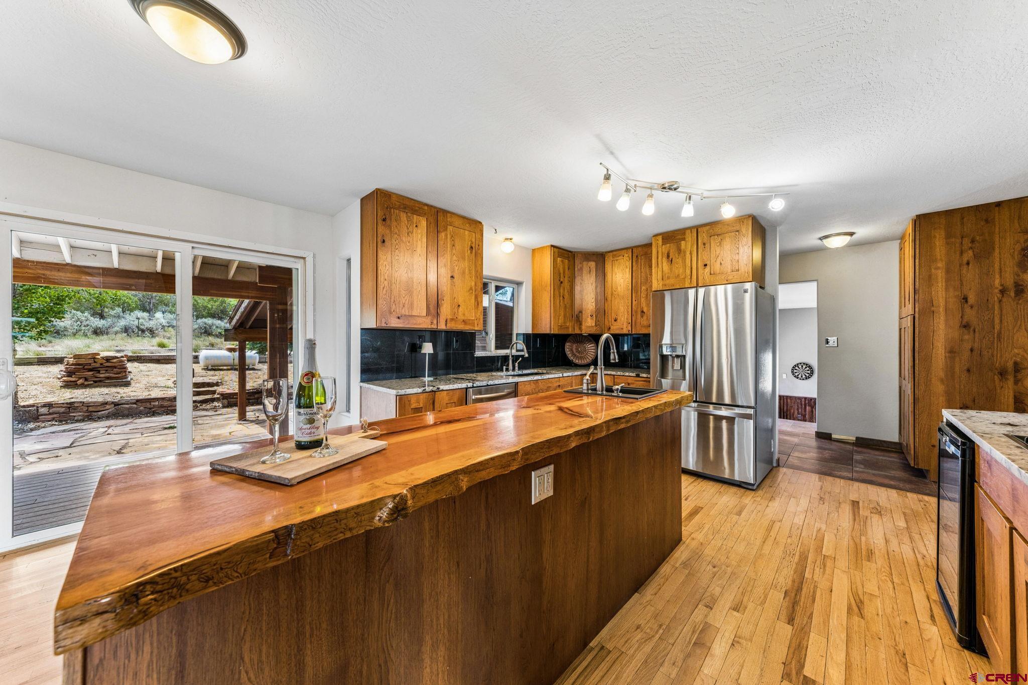 22480 Rd L Cortez, CO 81321 - Photo 11 of 44 a large kitchen with stainless steel appliances a large counter top a stove a refrigerator cabinets and a large window