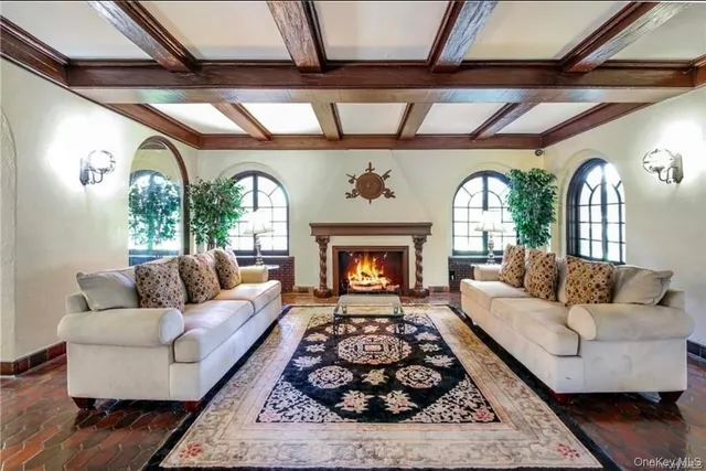 a living room with fireplace furniture and a large window