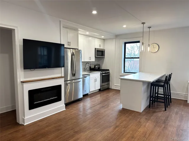 a kitchen with stainless steel appliances a stove a microwave and white cabinets