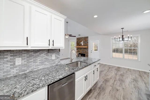 a kitchen with stainless steel appliances granite countertop a stove a sink and a microwave