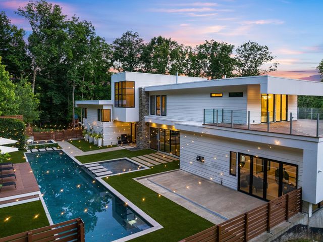 an aerial view of house with yard tennis court and mountain view in the back