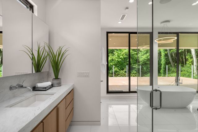 a bathroom with a tub sink and mirror