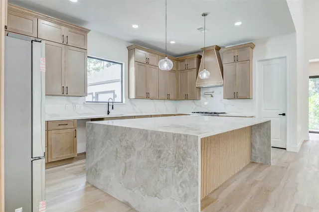 a large kitchen with granite countertop a sink a counter space and stainless steel appliances