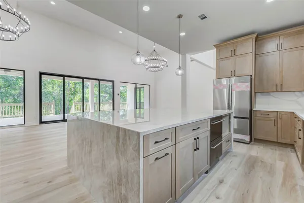 a large kitchen with stainless steel appliances a large counter top