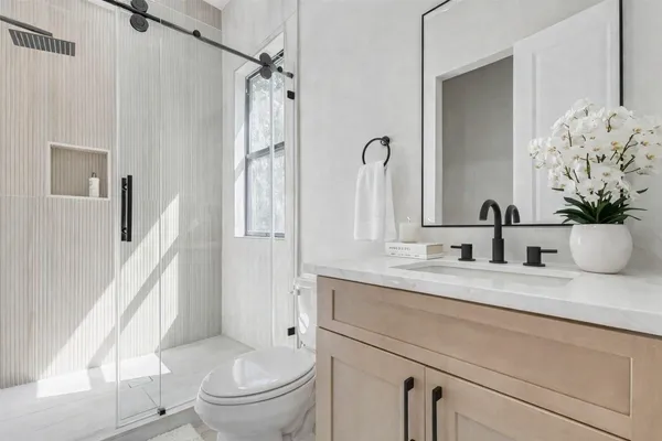 a bathroom with a granite countertop sink toilet and shower