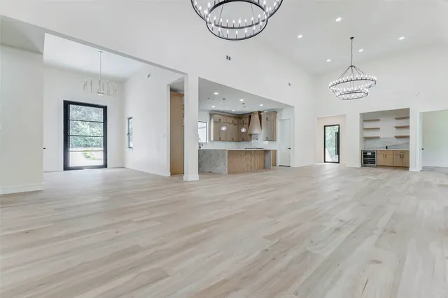 an empty room with wooden floor bathroom and windows