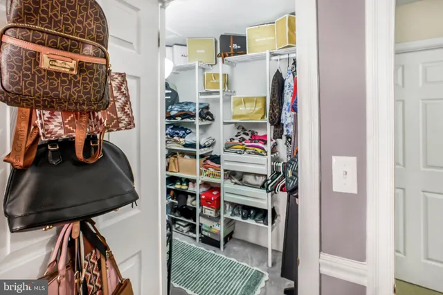 a view of walk in closet with clothes and shoes