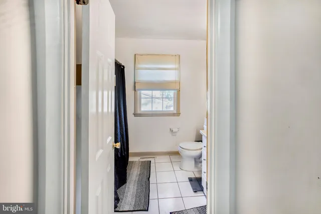 a bathroom with a toilet and a shower curtain