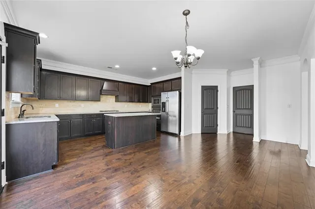 a kitchen with stainless steel appliances granite countertop a sink refrigerator and cabinets