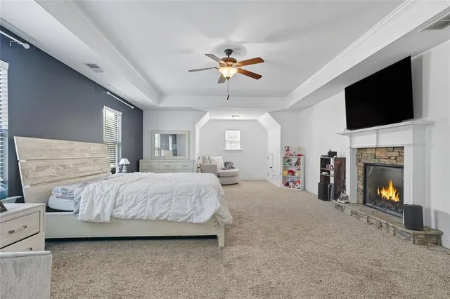 a spacious bedroom with a bed and a flat screen tv