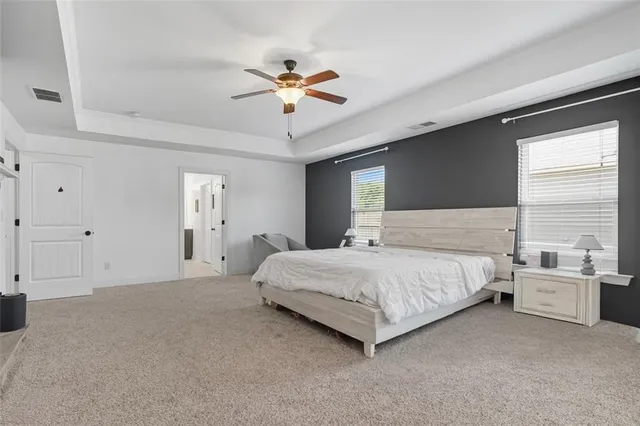 a bedroom with a large bed and ceiling fan